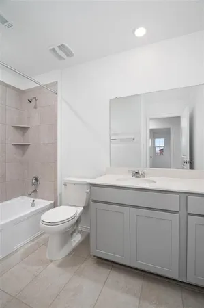 a bathroom with a double vanity sink a toilet and a bathtub
