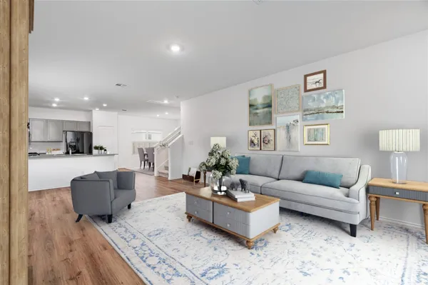 a living room with furniture and view of kitchen