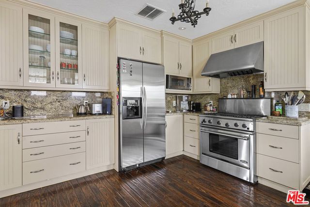 a kitchen with granite countertop a stove oven and a refrigerator