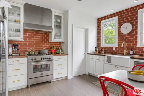 a kitchen with stainless steel appliances granite countertop a stove a sink and a large window