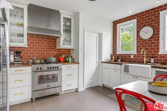 a kitchen with stainless steel appliances granite countertop a stove a sink and a large window