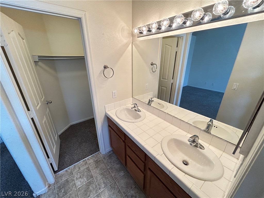 1840 Montvale Las Vegas, NV 89134 - Photo 26 of 31 Double vanity sinks and tiled countertops create a practical and appealing bathroom space.
