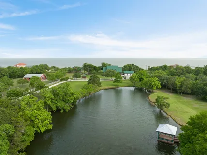 an aerial view of a house with a yard and lake view