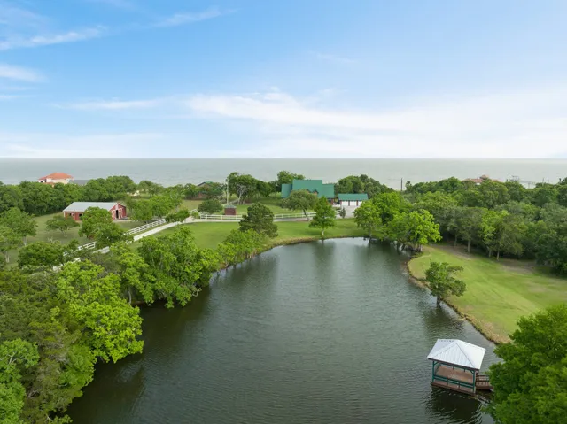 an aerial view of a house with a yard and lake view