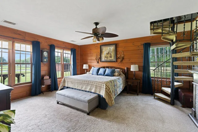 a spacious bedroom with a bed and a dresser next to a window