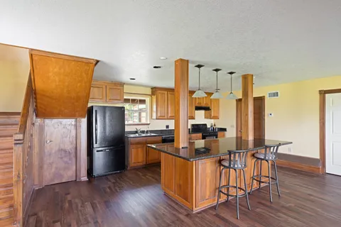 a kitchen with stainless steel appliances a refrigerator a stove top oven and wooden floors