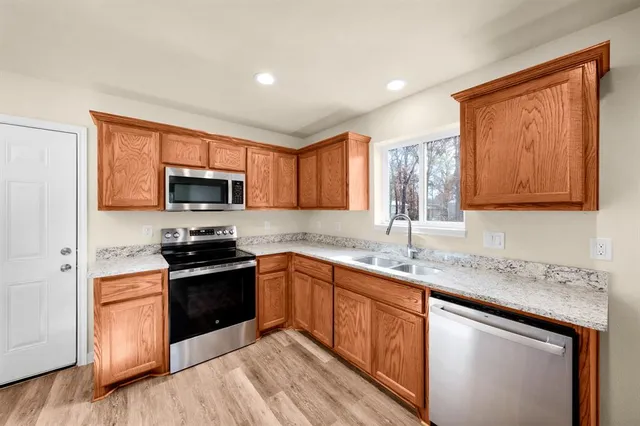 a kitchen with stainless steel appliances granite countertop a sink stove microwave and cabinets