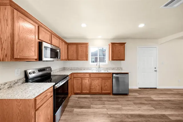 a kitchen with stainless steel appliances granite countertop a sink stove and refrigerator