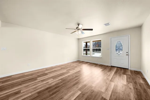 wooden floor in an empty room with a window