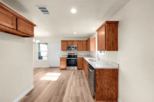 a kitchen with a sink appliances cabinets and a counter top space