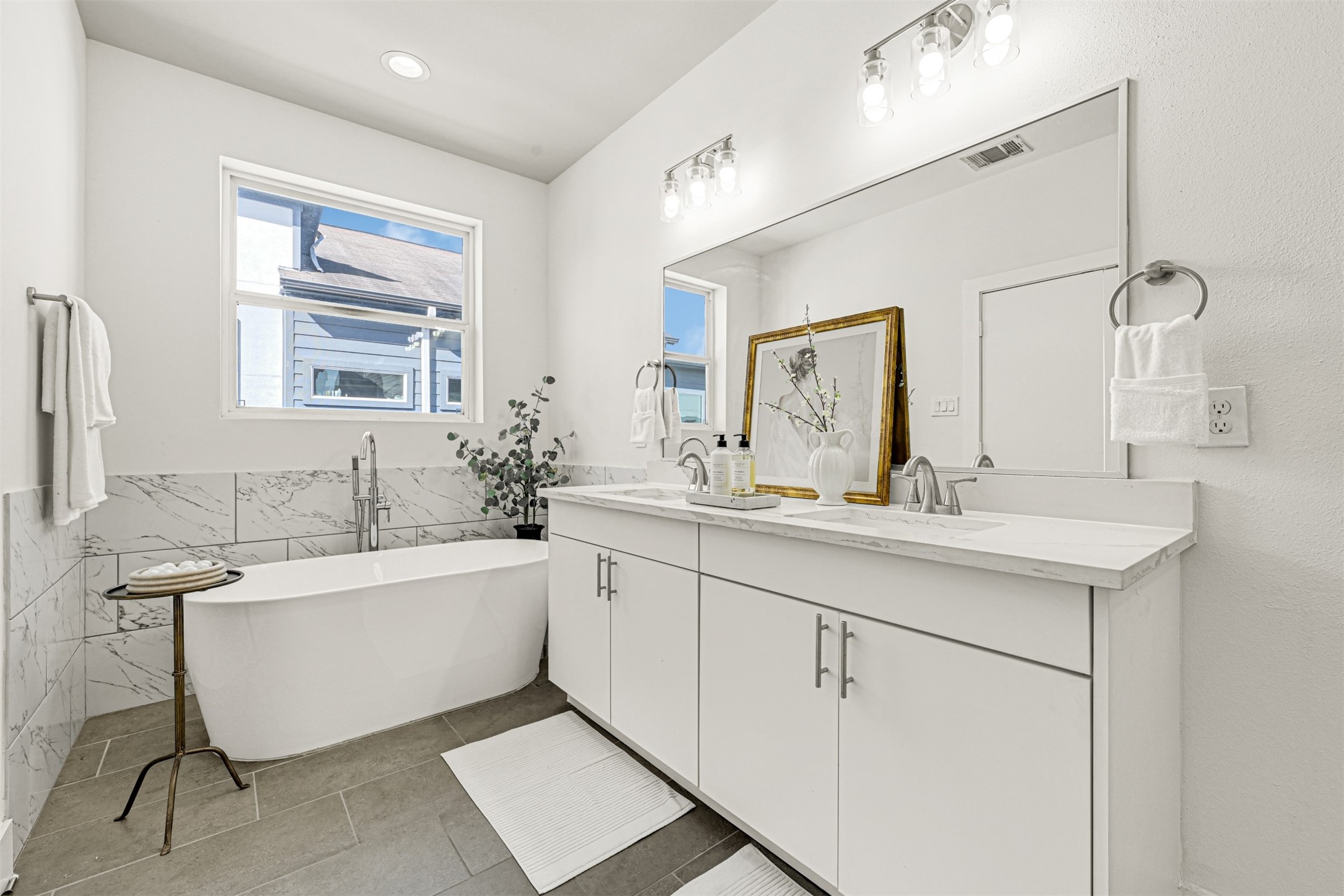 3313 Baer Street Houston, TX 77020 - Photo 23 of 35 a bathroom with a double vanity sink a mirror and a bathtub