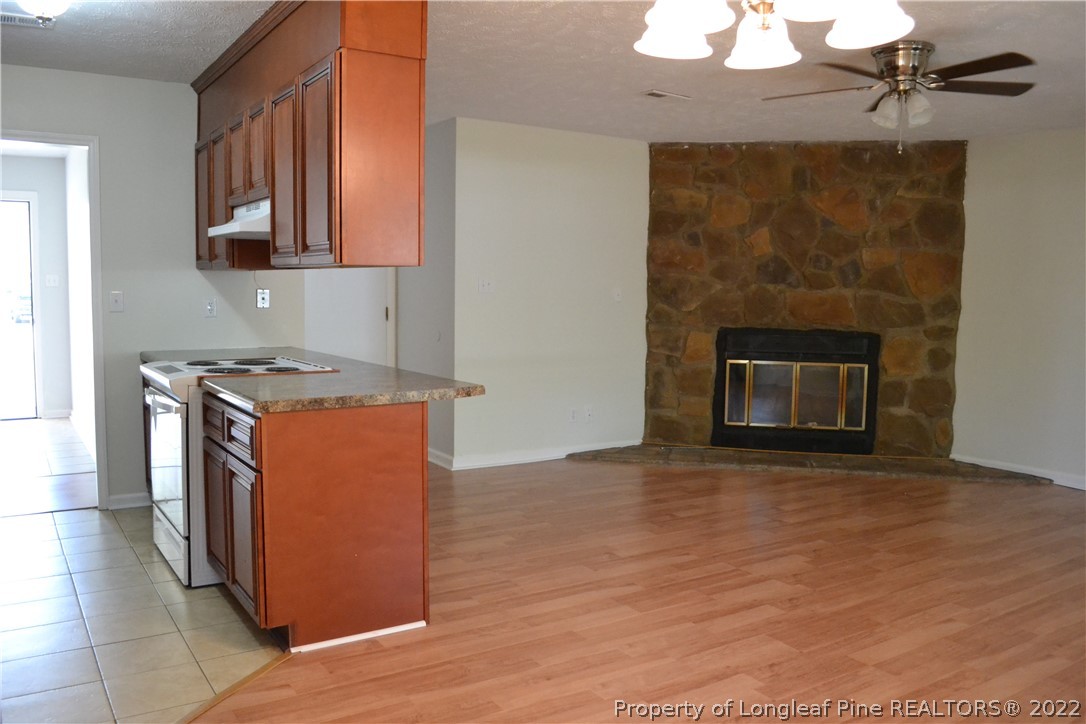 982 Rim Road Fayetteville, NC 28314 - Photo 6 of 20 a kitchen with granite countertop a stove a sink and a microwave