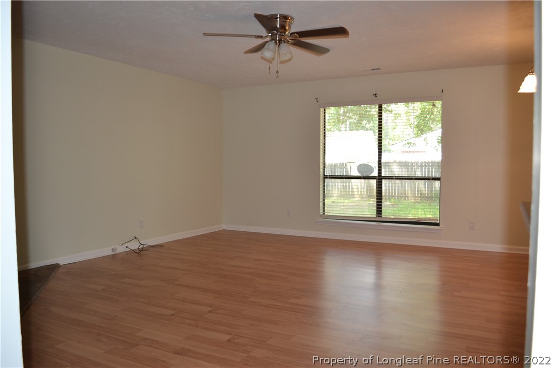 982 Rim Road Fayetteville, NC 28314 - Photo 8 of 20 an empty room with wooden floor ceiling fan and windows