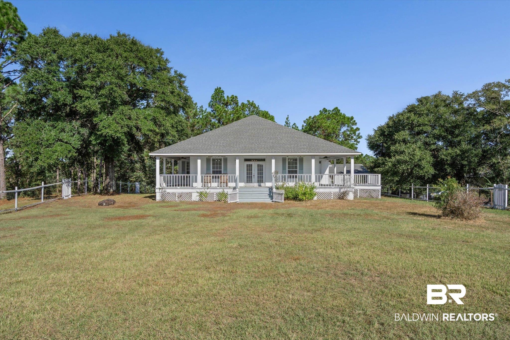 7650 Iron Rush Road Wilmer, AL 36587 - Photo 1 of 34 View of front of house with a fenced backyard, covered porch, french doors, and roof with shingles