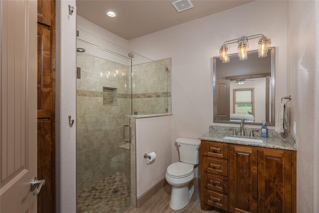 210 Spring Branch Trail North Springtown, TX 76082 - Photo 15 of 36 a bathroom with a toilet a sink and mirror
