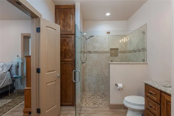 a bathroom with a granite countertop sink toilet and shower