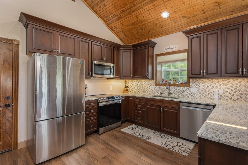210 Spring Branch Trail North Springtown, TX 76082 - Photo 10 of 36 a kitchen with stainless steel appliances granite countertop a refrigerator stove and sink