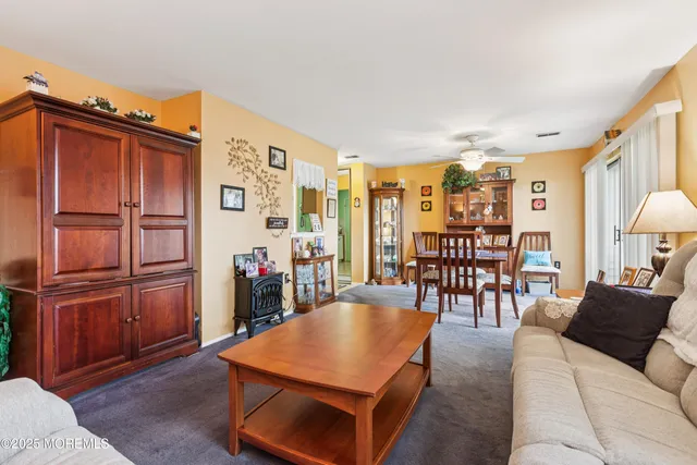 a living room with furniture a wooden floor and next to a window
