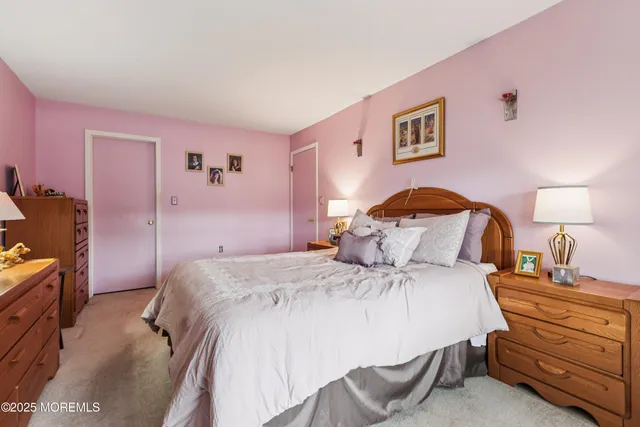 a bedroom with a bed and a lamp on dresser