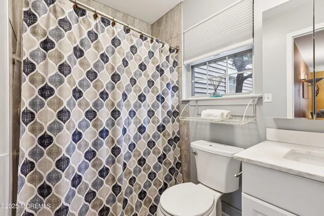 a white toilet sitting next to a shower curtain