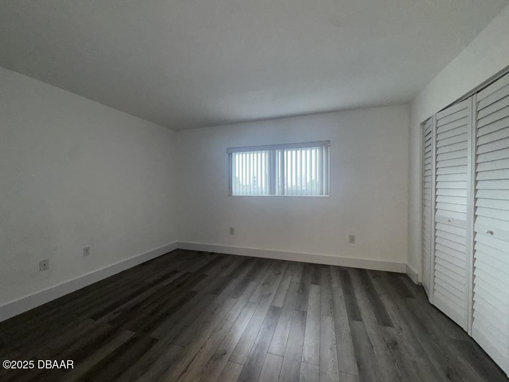 2711 North Halifax Avenue, Unit 385 Daytona Beach, FL 32118 - Photo 11 of 18 an empty room with wooden floor and windows