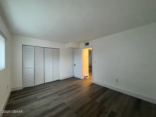an empty room with wooden floor and door