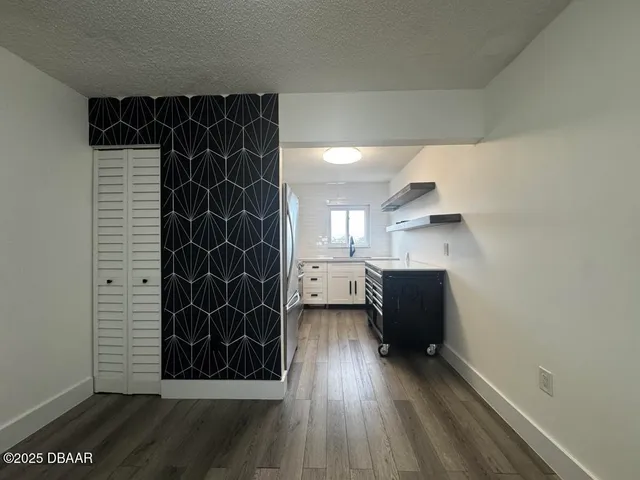 a view of empty room with wooden floor and black cabinet