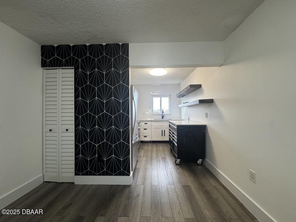2711 North Halifax Avenue, Unit 385 Daytona Beach, FL 32118 - Photo 4 of 18 a view of empty room with wooden floor and black cabinet
