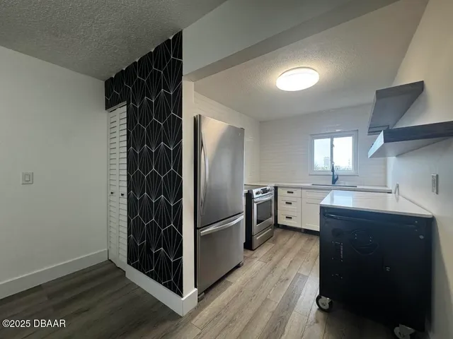 a kitchen with cabinets and stainless steel appliances