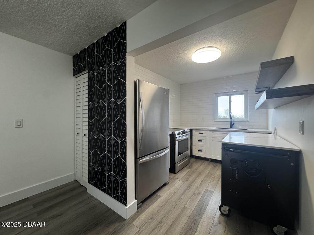 2711 North Halifax Avenue, Unit 385 Daytona Beach, FL 32118 - Photo 5 of 18 a kitchen with cabinets and stainless steel appliances