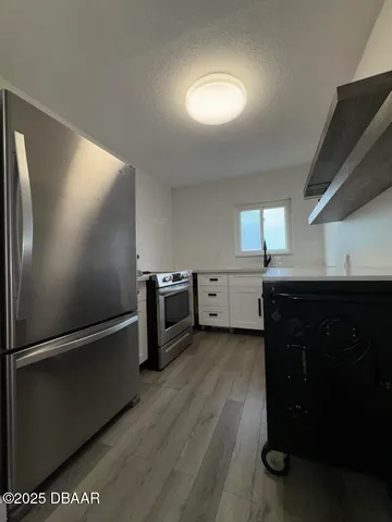 a kitchen with stainless steel appliances granite countertop a refrigerator a sink and a stove