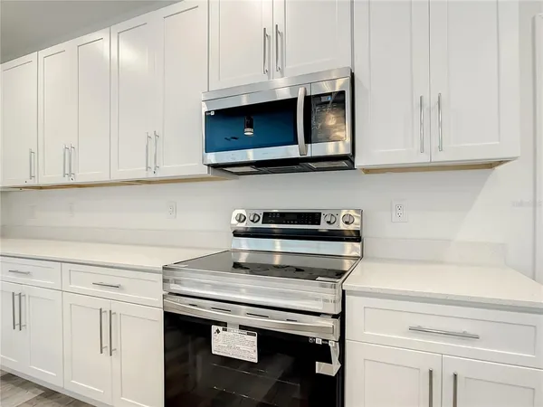 a kitchen with granite countertop white cabinets and a stove