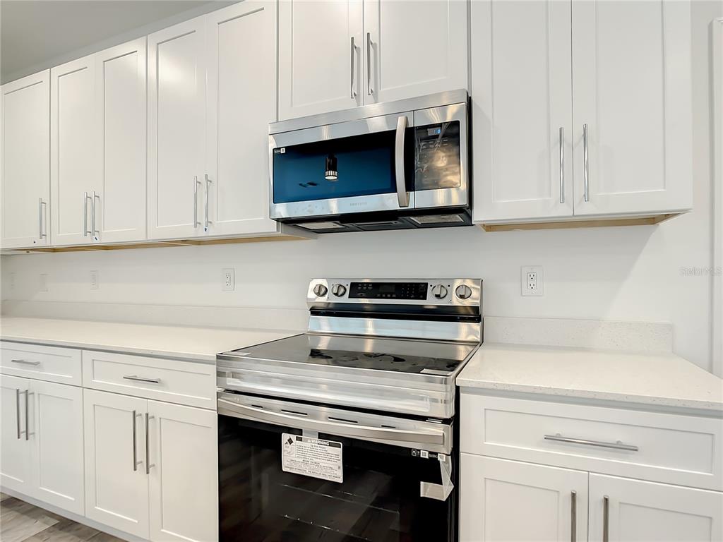 5123 Weatherton Street North Port, FL 34288 - Photo 5 of 16 a kitchen with granite countertop white cabinets and a stove