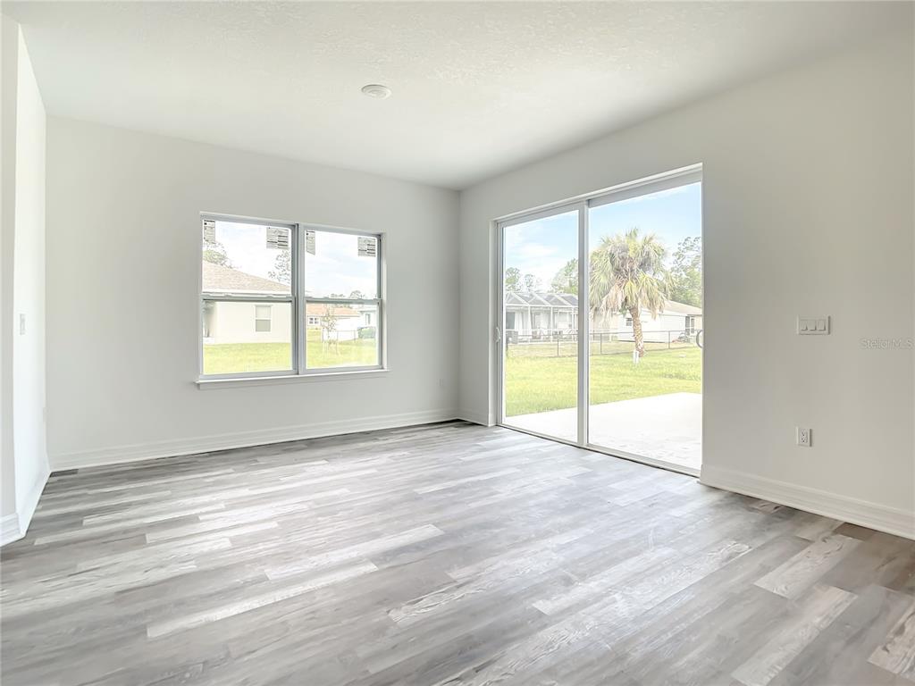 5123 Weatherton Street North Port, FL 34288 - Photo 7 of 16 a view of an empty room with wooden floor and a window
