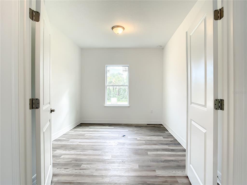 5123 Weatherton Street North Port, FL 34288 - Photo 8 of 16 a view of an empty room with wooden floor and a window