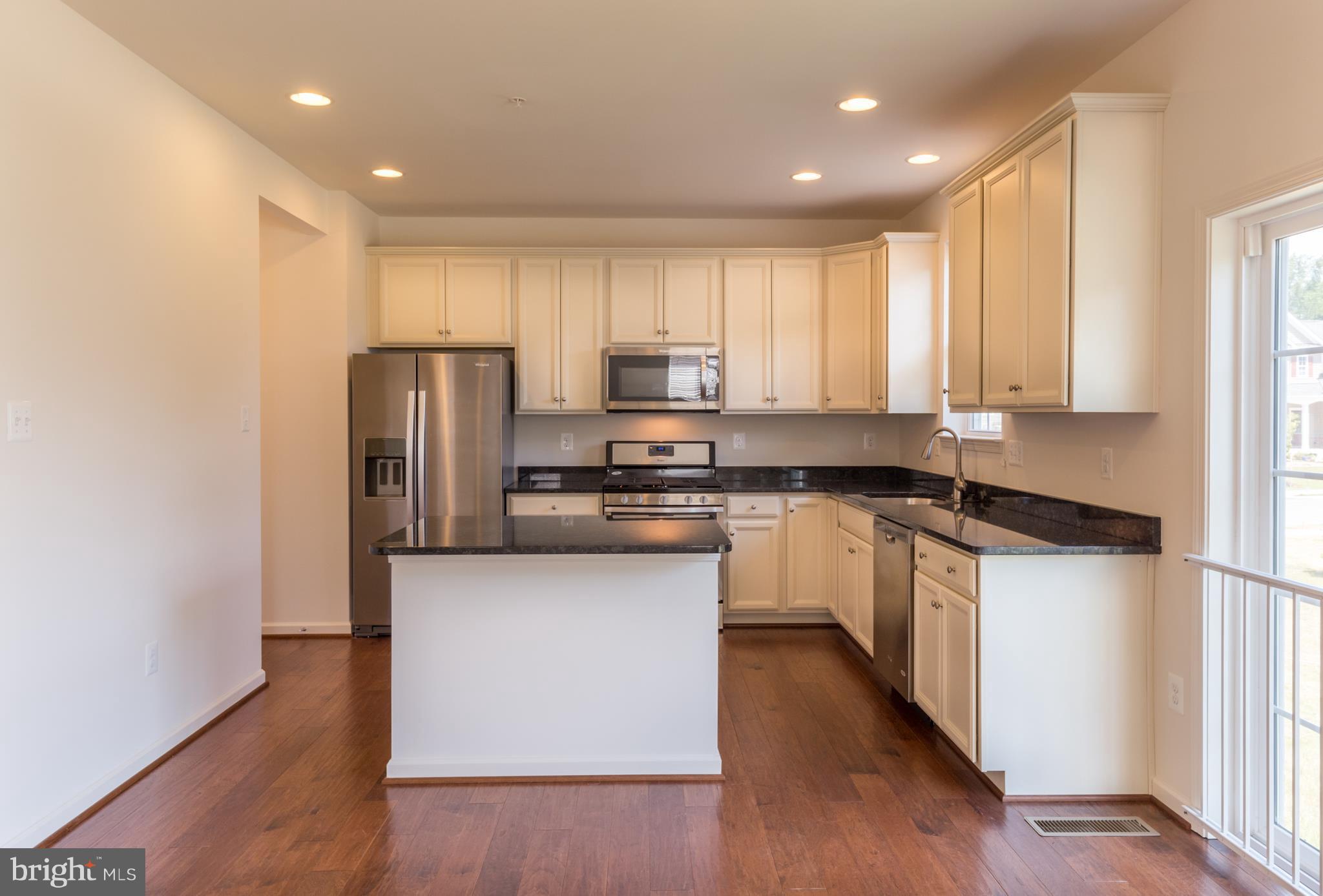 902 Ramble Run Road Middle River, MD 21220 - Photo 13 of 30 a kitchen with stainless steel appliances granite countertop a refrigerator a stove a sink and a microwave with wooden floor