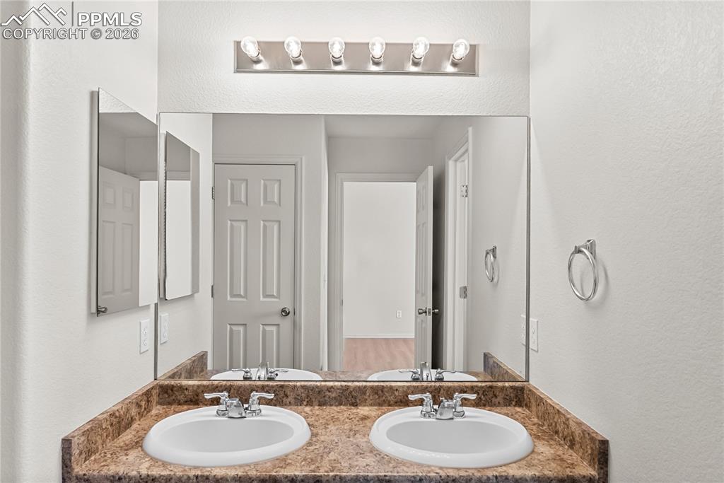 7795 Sandy Springs Point Fountain, CO 80817 - Photo 15 of 36 a bathroom with a double vanity sink and a mirror