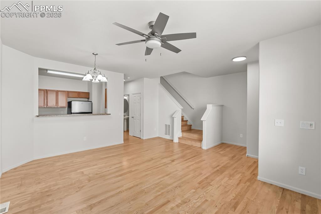 7795 Sandy Springs Point Fountain, CO 80817 - Photo 4 of 36 wooden floor in an empty room with a chandelier fan and wooden floor