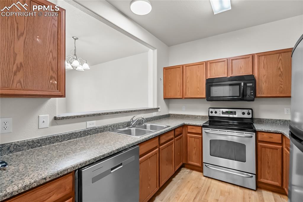 7795 Sandy Springs Point Fountain, CO 80817 - Photo 6 of 36 a kitchen with granite countertop a stove sink and microwave