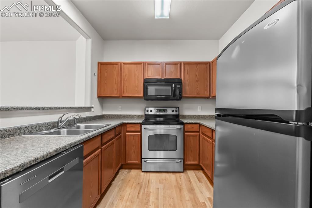 7795 Sandy Springs Point Fountain, CO 80817 - Photo 7 of 36 a kitchen with stainless steel appliances granite countertop a sink stove and microwave