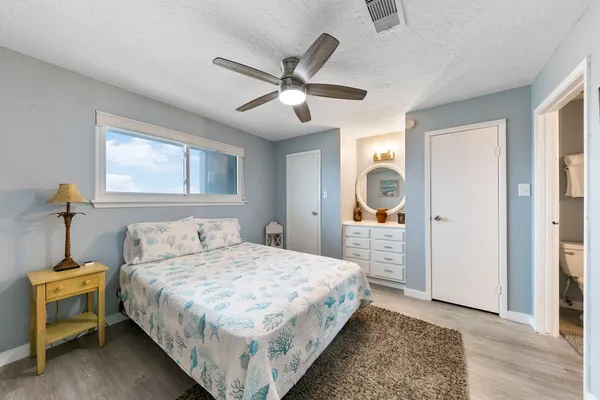 a bedroom with a large bed and a chandelier