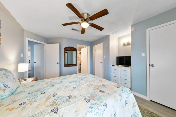 a bedroom with a large bed and a flat tv screen
