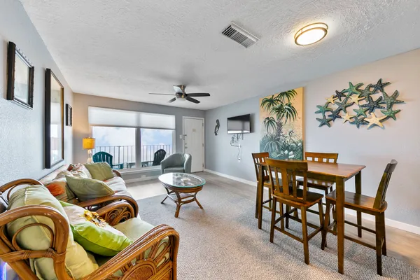 a dining room with furniture and a large window