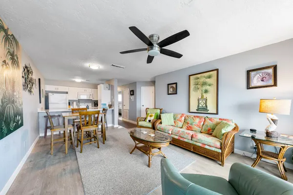 a living room with furniture kitchen view and a window
