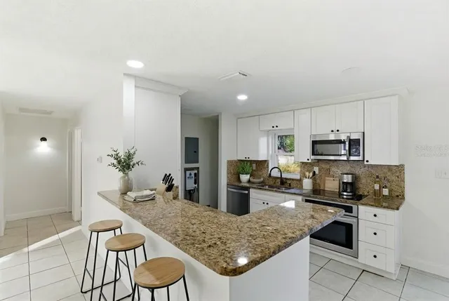 a kitchen with stainless steel appliances granite countertop a sink counter space and cabinets