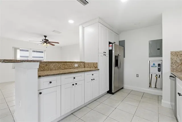 a kitchen with stainless steel appliances granite countertop a refrigerator and a sink