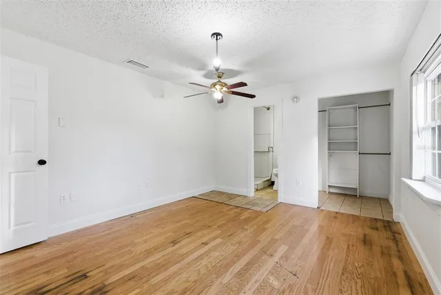 a view of a room with wooden floor and a ceiling fan