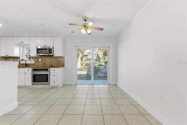 a kitchen with granite countertop a stove top oven microwave and cabinets