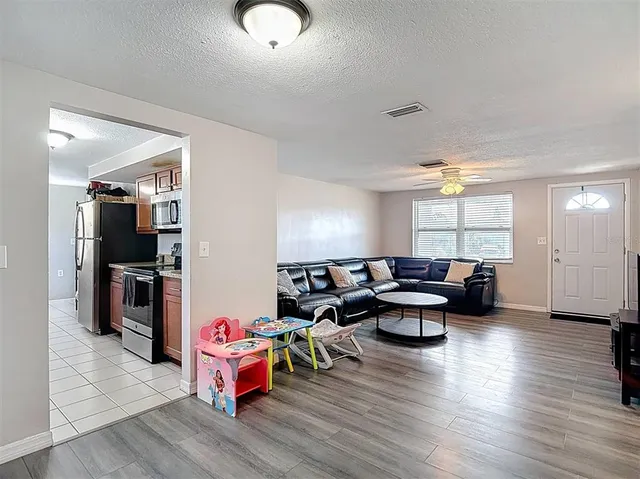 a kitchen with granite countertop a refrigerator stove and microwave