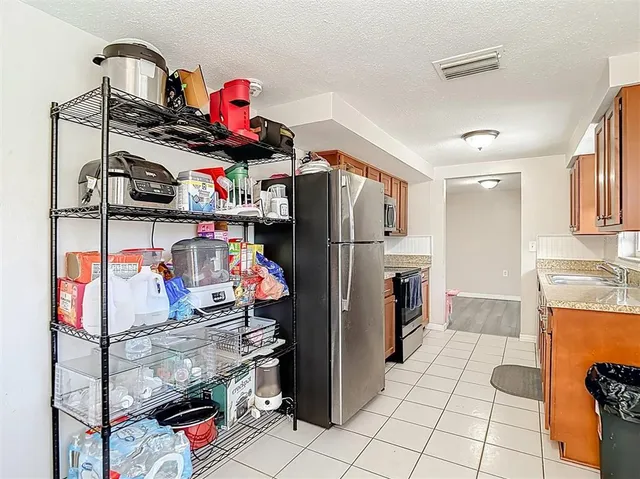 a kitchen with stainless steel appliances granite countertop a refrigerator a stove top oven a sink and dishwasher